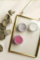 Cosmetics facial powder and blush for cheeks on natural background with dried flowers. Makeup accessories top view photo