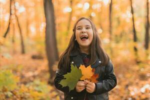 Autumn emotional portrait of laughing child walking in park or forest photo