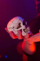 Halloween witch making magic with scull in halloween night. Magic, holidays and mystic concept. photo