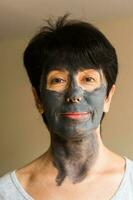 Beautiful woman with facial mask. Cosmetology, spa, skin care and people concept. photo