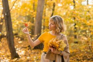 Portrait of beautiful young woman walking outdoors in autumn. Fall season and stylish girl concept. photo