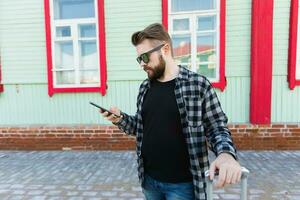 Bearded tourist man lost in city and using smartphone online map to find right directions. Travel and trip concept. photo