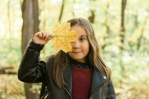 Autumn emotional portrait of laughing child walking in park or forest photo