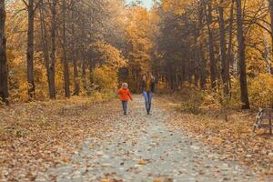 Mother and son walking in the fall park and enjoying the beautiful autumn nature. Season, single parent and children concept. photo