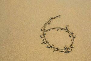 Six number written on sand on summer beach photo