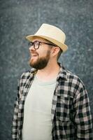 Handsome guy tourist looking happy wearing straw hat for travelling, standing against concrete wall background with copy space photo