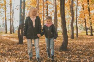 Grandmother with granddaughter in autumn park. Generation and family concept. photo