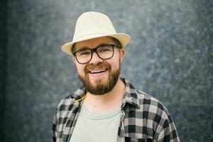 Handsome guy tourist looking happy wearing straw hat for travelling, standing against concrete wall background with copy space photo