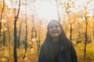 otoño emocional retrato de riendo niño caminando en parque o bosque foto