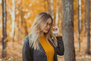 Portrait of beautiful woman wearing fashion glasses during the autumn. Stylish youth and fall season concept. photo