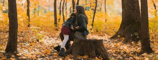 Banner mother and daughter spend time together in autumn yellow park copy space. Season and single parent concept. photo