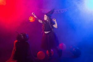 Funny child girl in witch costume for Halloween with pumpkin Jack. photo