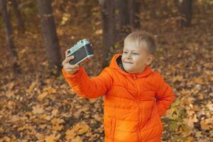 Boy in park in autumn taking selfie photo. Fall and leisure concept. photo