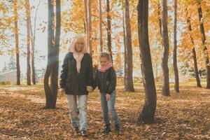 Grandmother with granddaughter in autumn park. Generation and family concept. photo