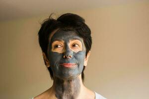 Beautiful woman with facial mask. Cosmetology, spa, skin care and people concept. photo