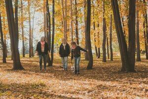 Grandmother and mother with granddaughter walks together in autumn park and having fun. Generation, leisure and family concept. photo