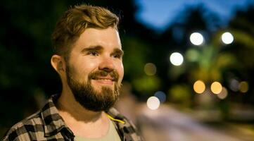 Banner portrait of man standing in night city street with copy space and place for text. Confident happy guy. Close-up portrait photo