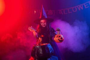 Little witch child cooking potion in the cauldron on Halloween. photo