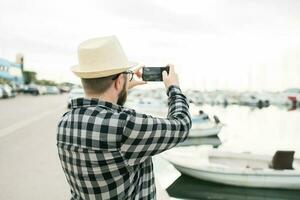 viajero hombre tomando imágenes de lujo yates marina durante soleado día - viaje y verano concepto foto