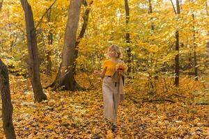 Portrait of beautiful young woman walking outdoors in autumn nature. Fall season and stylish girl concept. photo