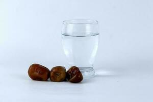 Dates and a glass of water isolated on a white background photo