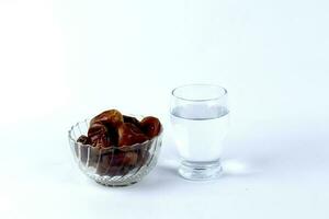 Dates and a glass of water isolated on a white background photo