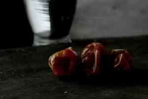 Dates and a glass of water isolated on a black background photo