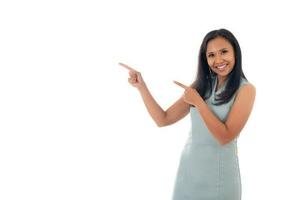 smiling mixed race asian woman pointing with two hands and fingers to the side ,isolated over white background with copyspace for text photo