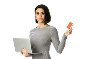 Portrait of confident businesswoman hold laptop and bank card in her hands. Isolated over white background photo