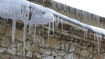 Ice Eaves Hanging from Corrugated Aluminum Sheet Roof of Village House in Winter video
