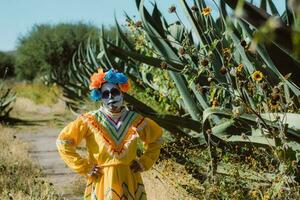 Mexican woman in colorful dress and skull makeup in the mexican desert photo