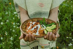 In Mexico, chilaquiles are a delicious and popular dish made with fried tortillas, sauce photo