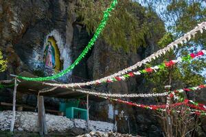 Image of guadalupe painted on a natural rock wall in mexico photo