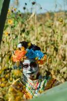 mexicano mujer en vistoso vestir y cráneo maquillaje en el mexicano Desierto cactus foto