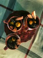 A delightful bowl of Mexican ponche, featuring cane and tejocote, served on wooden tableware photo