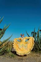 mexicano mujer en vistoso vestir y cráneo maquillaje en el mexicano Desierto cactus foto