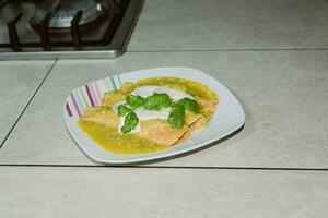 The Mexican enchiladas verdes, a staple food in Mexican cuisine, are served on a plate photo