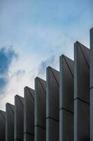 Towering skyscraper with a composite facade, reflecting clouds, nature, and urban design. photo