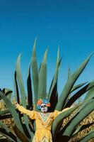 Mexican woman in colorful dress and skull makeup in the mexican desert cactus photo