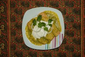 The Mexican enchiladas verdes, a staple food in Mexican cuisine, are served on a plate photo