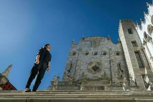 un estudiante explorador el animado calles de guanajuato, México, con el icónico Universidad edificio en el antecedentes foto