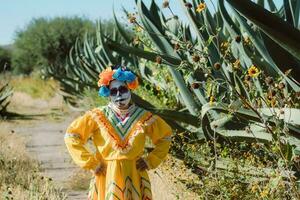 Mexican woman in colorful dress and skull makeup in the mexican desert photo