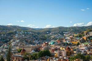 Stunning view of Guanajuato city from the Basilica, with clouds floating in the sky and a picturesque mountain backdrop photo