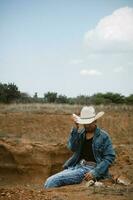 Cowboy under the vast sky, surrounded by cacti, working on a farm photo