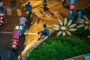 Ho Chi Minh, Viet Nam - 24 April 2023 Vietnamese crowned people with rush hour in heavy rain and traffic jam photo