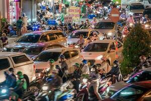 Ho Chi Minh, Viet Nam - 24 April 2023 Vietnamese crowned people with rush hour in heavy rain and traffic jam photo