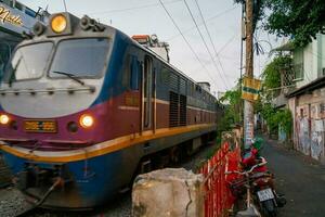 Ho Chi Minh, Viet Nam - 8 April 2023 Incredible view of train passing through a narrow street, the Hanoi Old Quarter. Stock photo