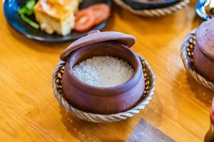 Clay pot used to hold white rice, typical in Vietnam and Asia photo