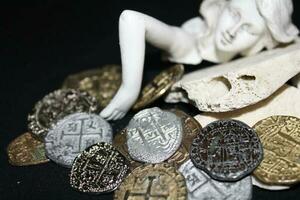 sirena tendido en conchas conmovedor monedas desde un tesoro pecho. foto