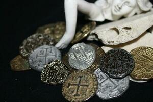 Mermaid laying On Shells Touching Coins From A Treasure Chest. photo